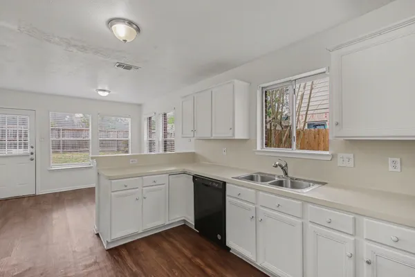 a kitchen with white cabinets and black appliances