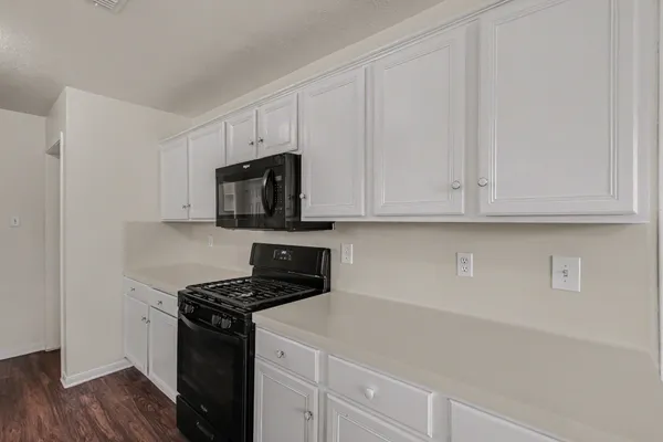a kitchen with a sink cabinets stainless steel appliances and a window