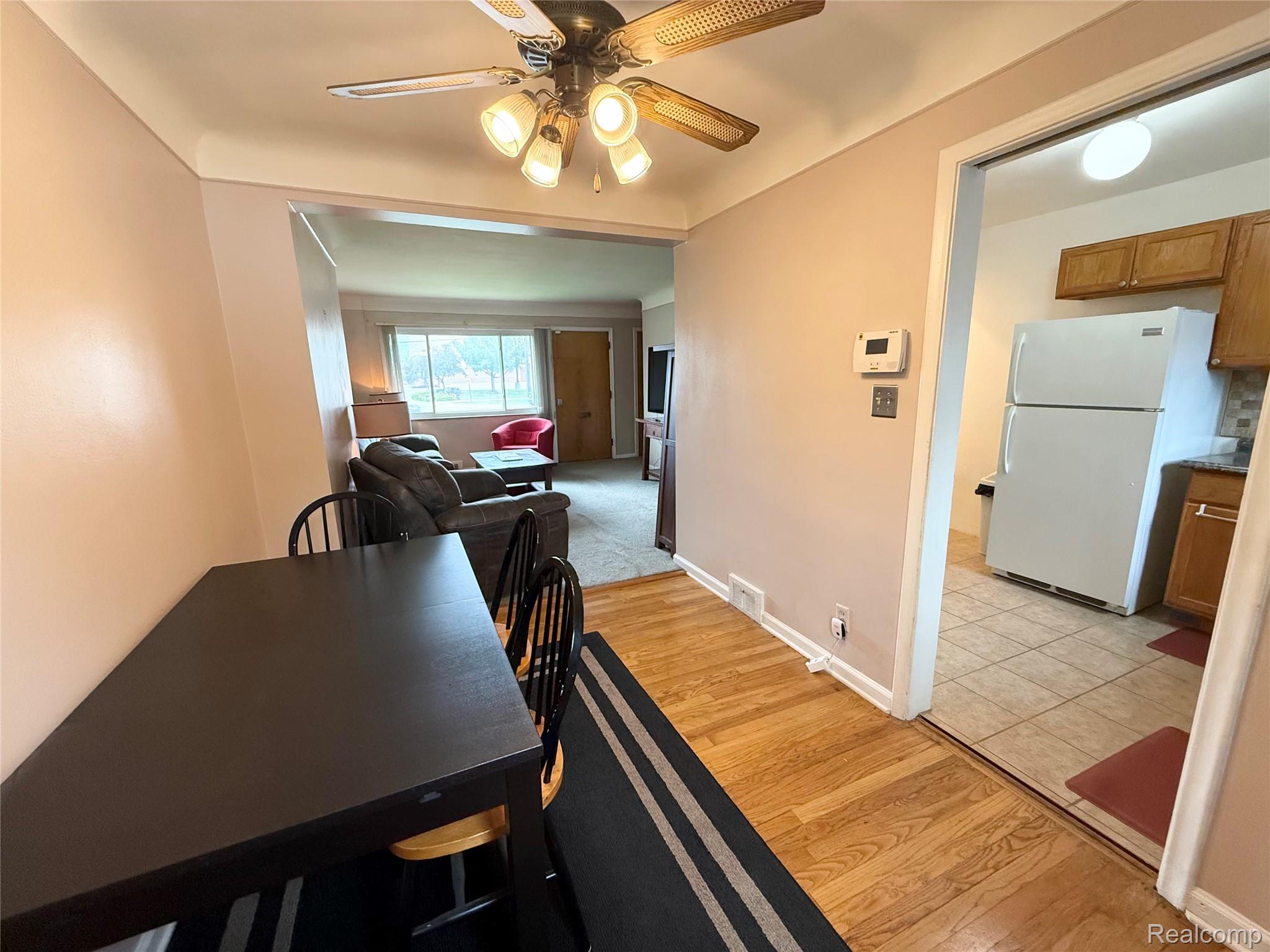 11012 Middlebelt Road Livonia, MI 48150 - Photo 4 of 14 Dining area featuring wood-finish flooring, a ceiling fan with integrated lighting, and an open doorway to the living room