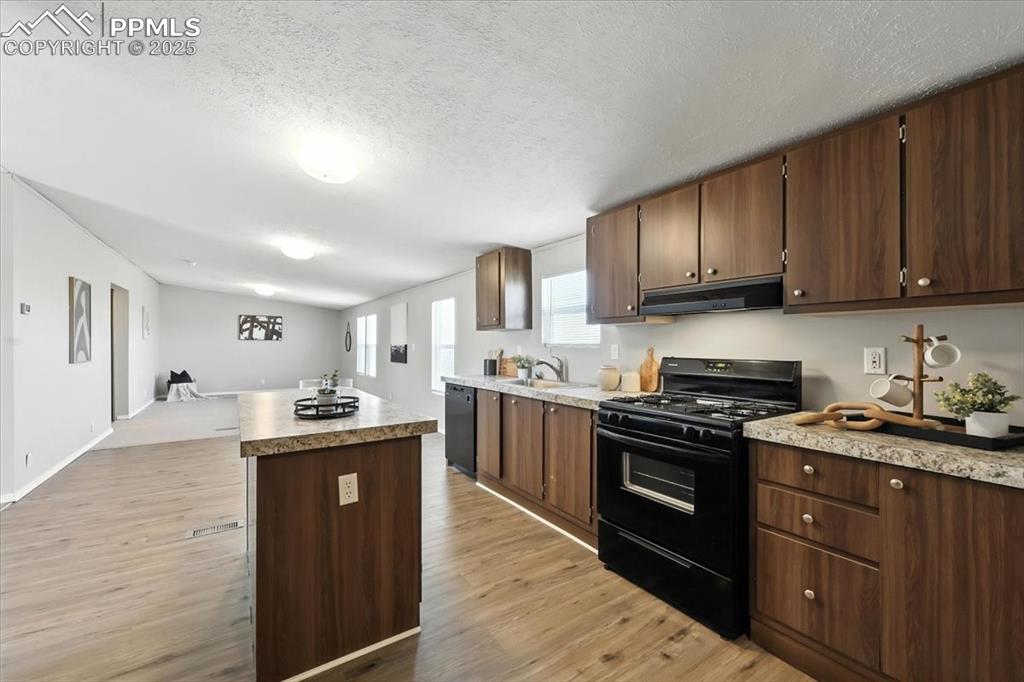 13560 Whittemore Road Yoder, CO 80864 - Photo 10 of 50 a kitchen with granite countertop cabinets stainless steel appliances and wooden floor