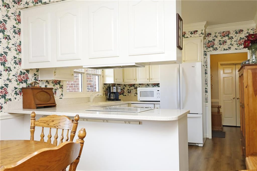 1670 Deep Creek Church Road Burlington, NC 27217 - Photo 16 of 36 a kitchen with stainless steel appliances granite countertop a refrigerator a stove and white cabinets with wooden floor