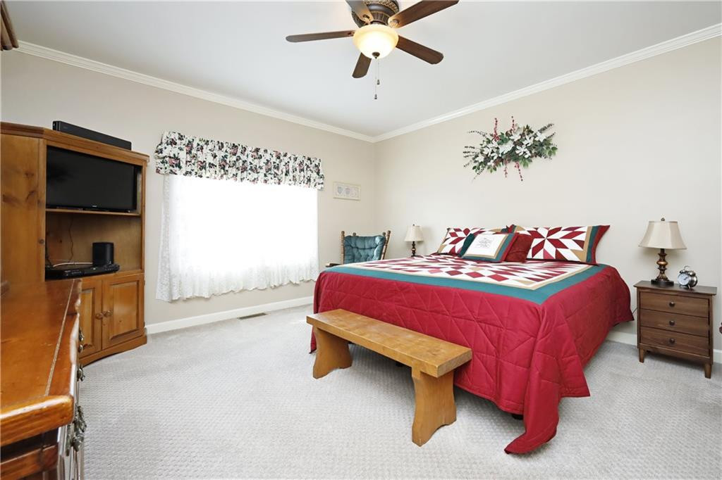 1670 Deep Creek Church Road Burlington, NC 27217 - Photo 19 of 36 a spacious bedroom with a bed and a chandelier