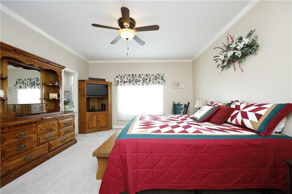 1670 Deep Creek Church Road Burlington, NC 27217 - Photo 20 of 36 a bedroom with a large bed and a chandelier