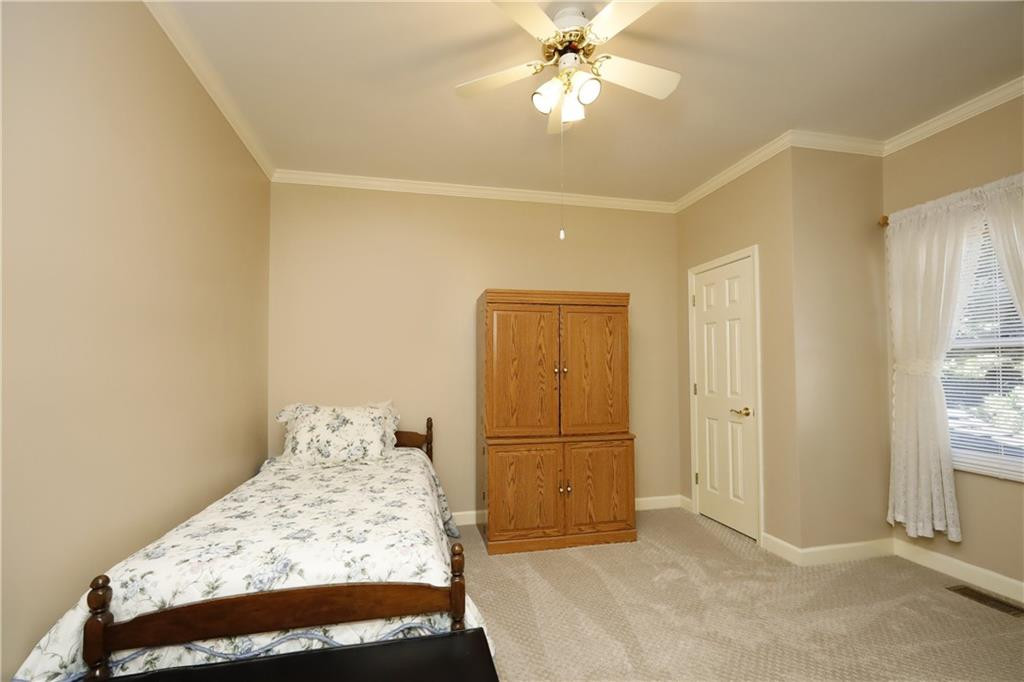 1670 Deep Creek Church Road Burlington, NC 27217 - Photo 22 of 36 a bedroom with a bed and a chandelier