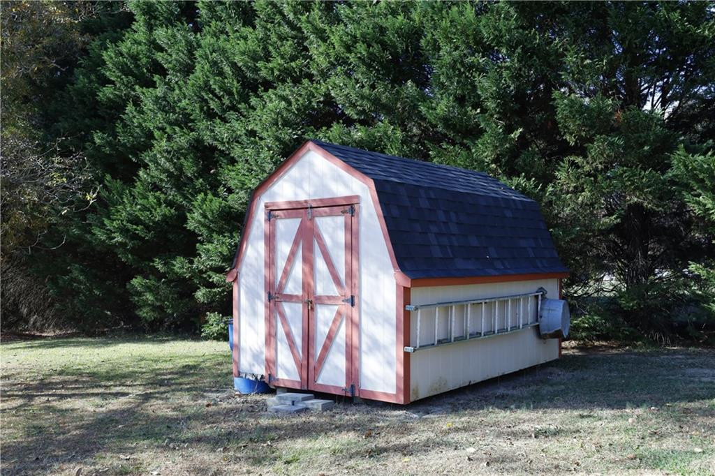 1670 Deep Creek Church Road Burlington, NC 27217 - Photo 34 of 36 a view of a backyard with a small cabin and wooden fence