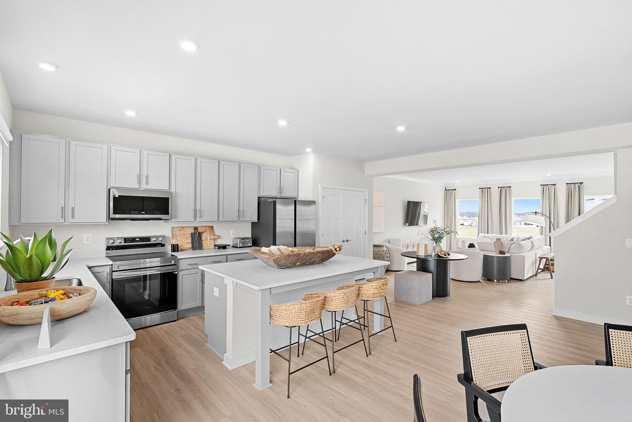 23 Elmiraj Court Inwood, WV 25428 - Photo 6 of 26 a kitchen with stainless steel appliances kitchen island granite countertop a stove a sink a dining table and chairs