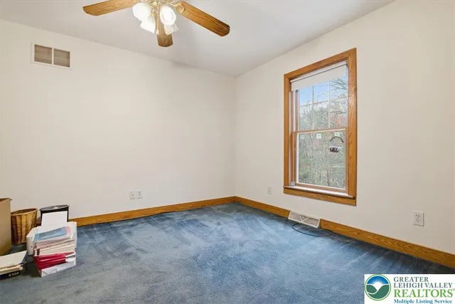 a view of empty room with wooden floor and ceiling fan