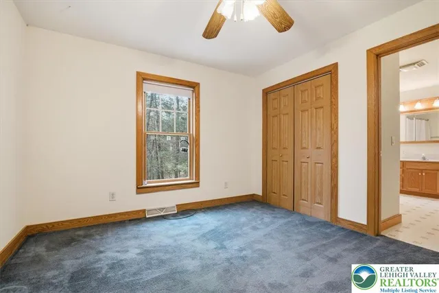a view of an empty room with wooden floor fireplace and a window