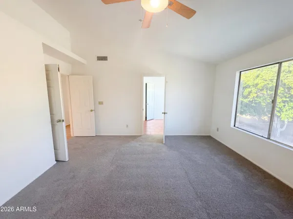 an empty room with a window and a fan