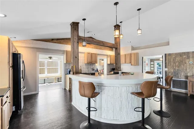 a living room with furniture a large window and wooden floor