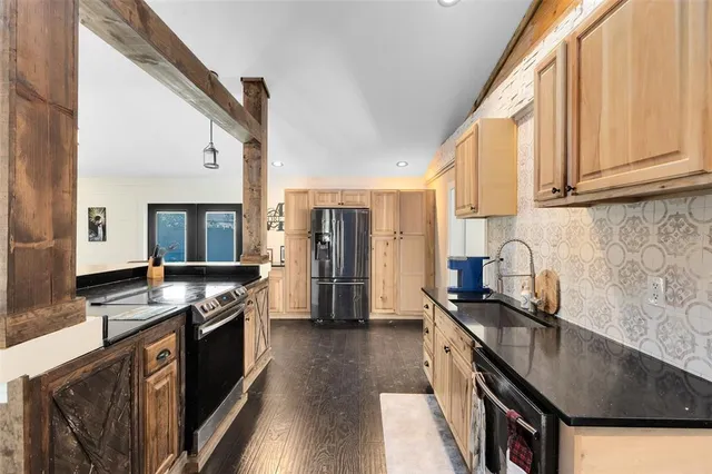 a kitchen with stainless steel appliances granite countertop a stove a sink and a refrigerator