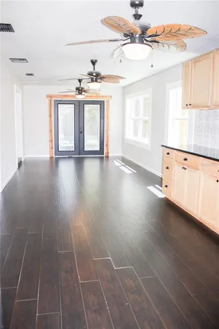 a view of an empty room with window and wooden floor