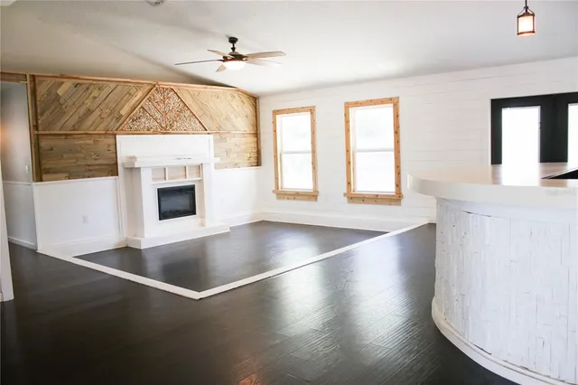a view of an empty room with window and wooden floor