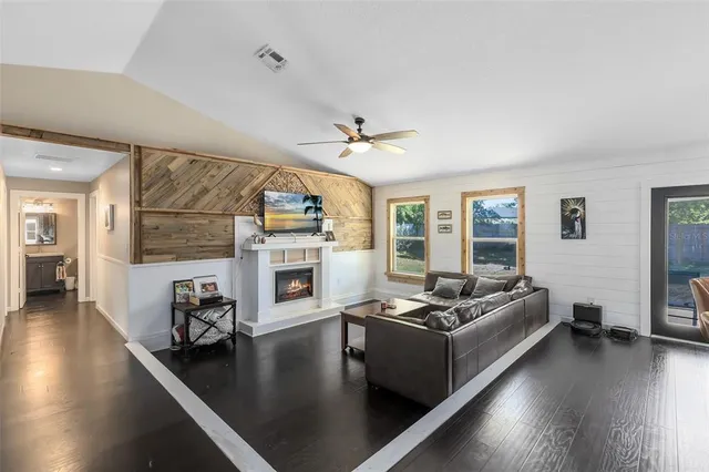 a living room with fireplace furniture and a wooden floor