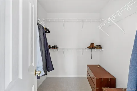 a view of walk in closet with clothes and shoes