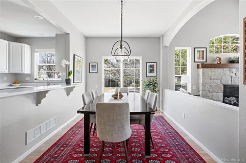 a dining room with furniture a chandelier and wooden floor
