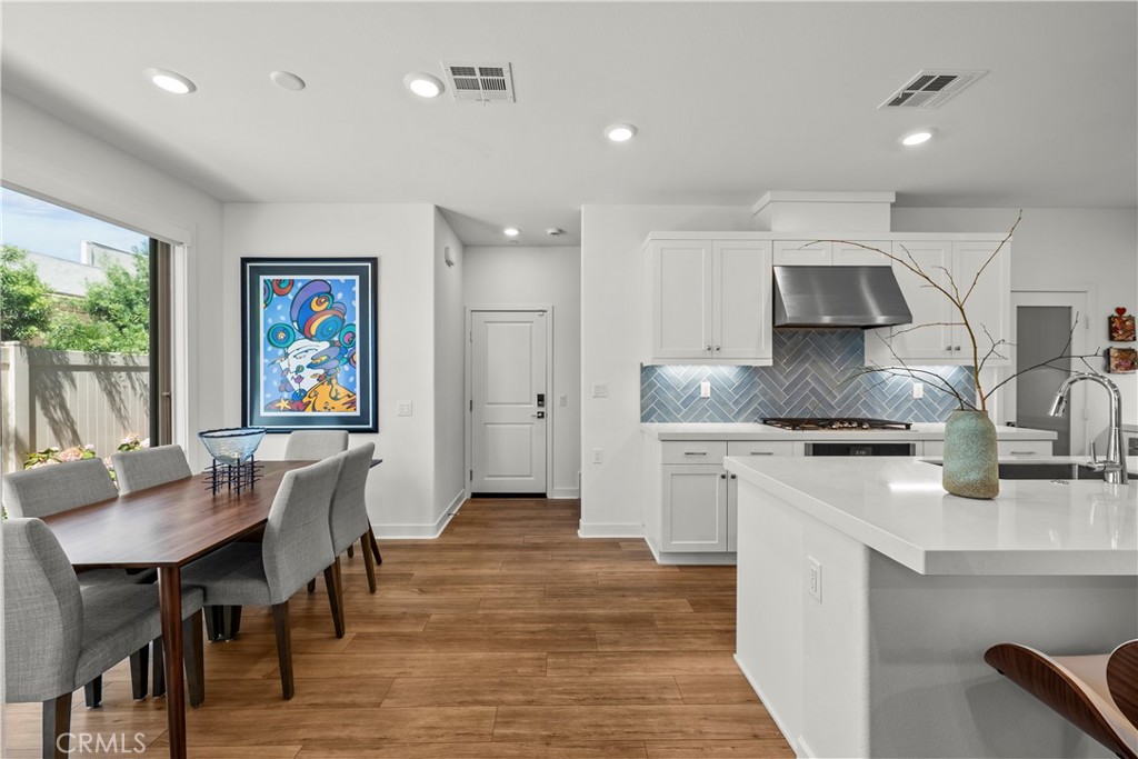 1663 Rosewell Road West Covina, CA 91791 - Photo 10 of 45 a kitchen with granite countertop a table chairs stove and wooden floor