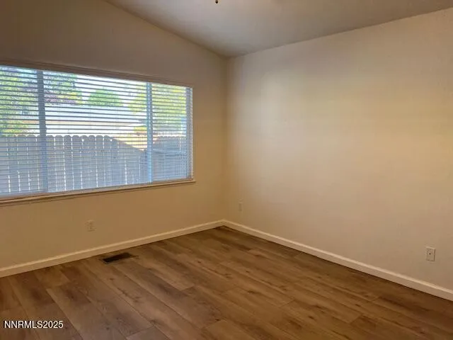 a view of a room with wooden floor and a window