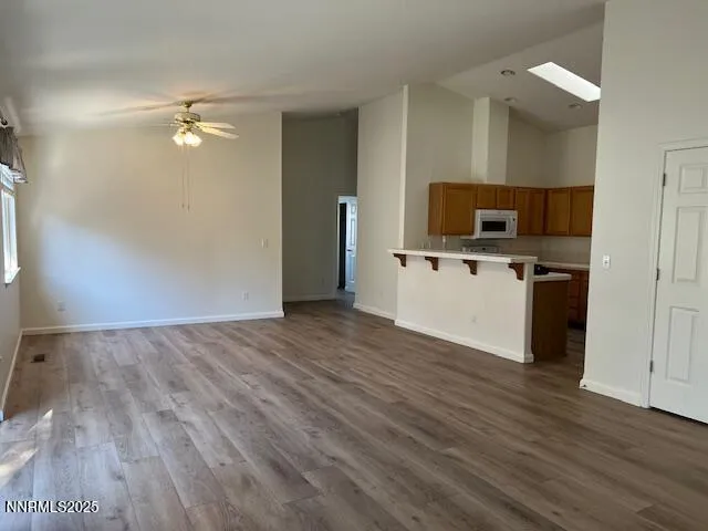 a view of a kitchen with wooden floor and a ceiling fan