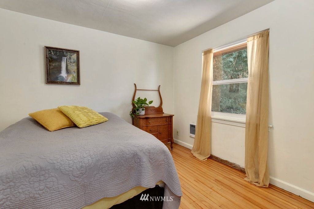 524 Southwest Sunset Boulevard Renton, WA 98057 - Photo 10 of 22 a bedroom with a bed and wooden floor