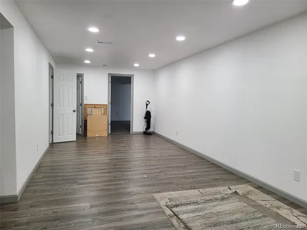 a view of empty room with wooden floor