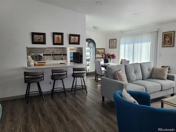 a living room with furniture and a wooden floor