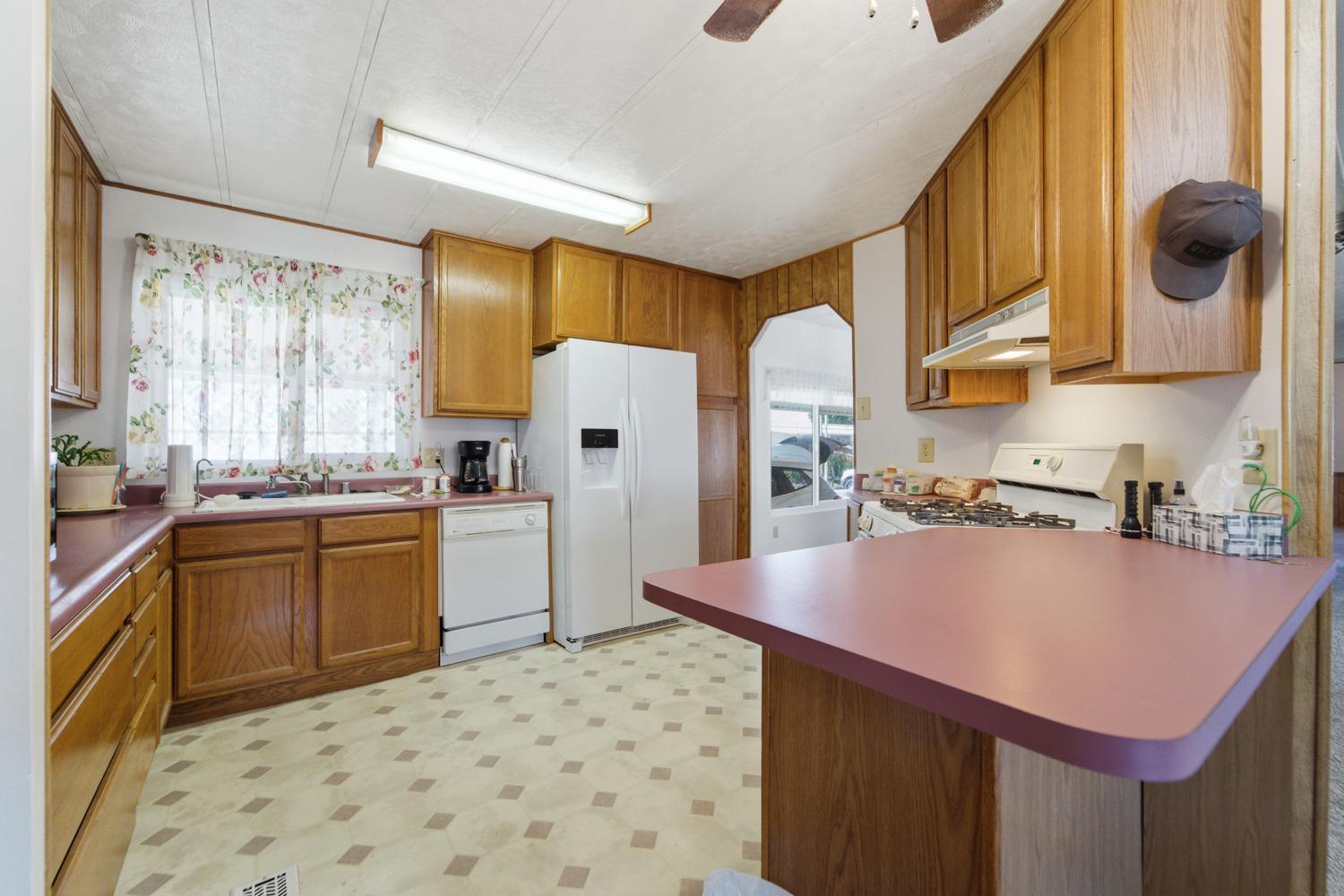 1155 Pease Road, Unit 514 Yuba City, CA 95991 - Photo 11 of 21 a kitchen with a sink refrigerator and cabinets