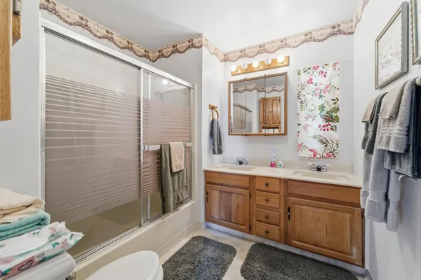 a bathroom with a sink a toilet and shower