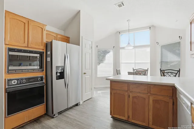 a kitchen with stainless steel appliances a refrigerator a stove a sink and cabinets