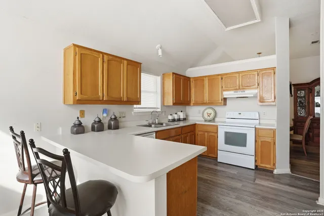 a kitchen with a table chairs stove and cabinets