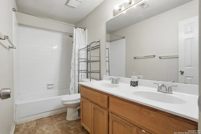a bathroom with a double vanity sink toilet mirror and bathtub