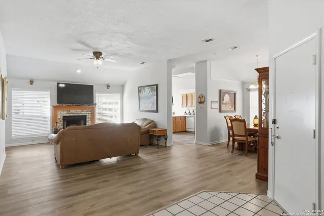 a living room with furniture a fireplace and a view of kitchen