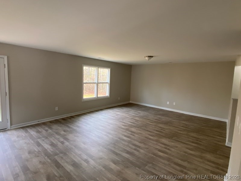 3034 Cricket Road Fayetteville, NC 28306 - Photo 5 of 11 a view of an empty room with wooden floor and a window