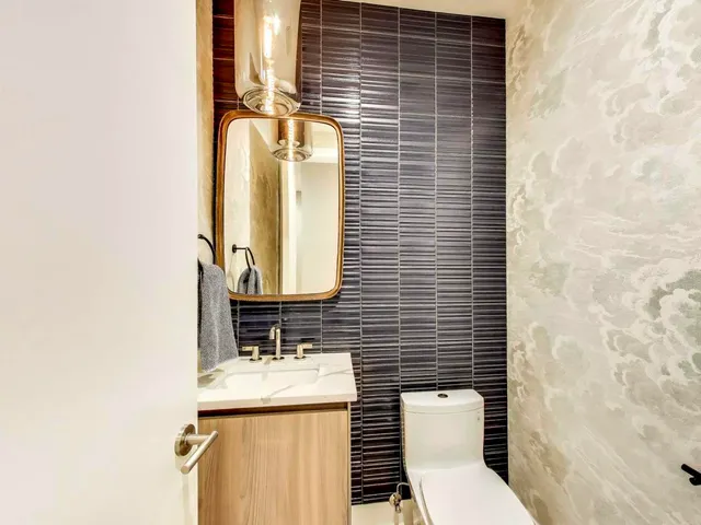 a bathroom with a toilet a sink and mirror