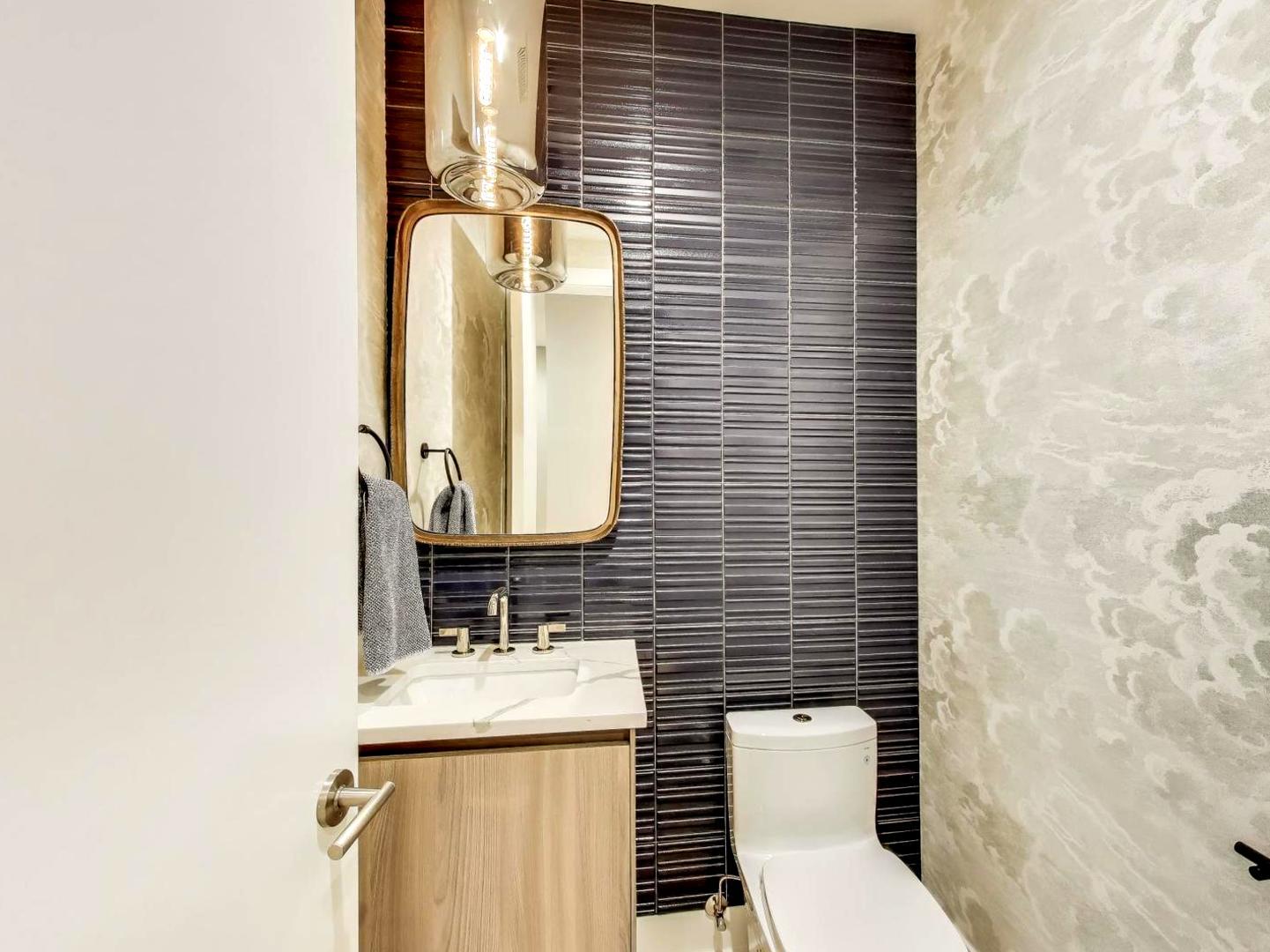 6 North Carpenter Street, Unit 5B Chicago, IL 60607 - Photo 13 of 40 a bathroom with a toilet a sink and mirror