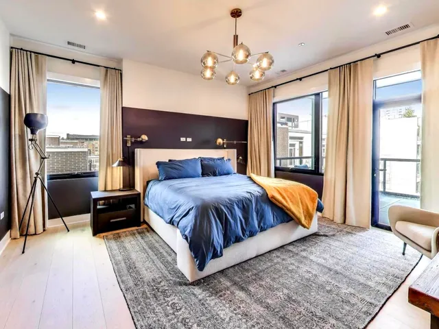 a bedroom with a large bed and a chandelier