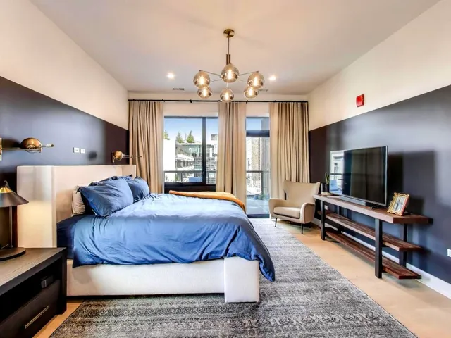 a living room with a bed and flat screen tv