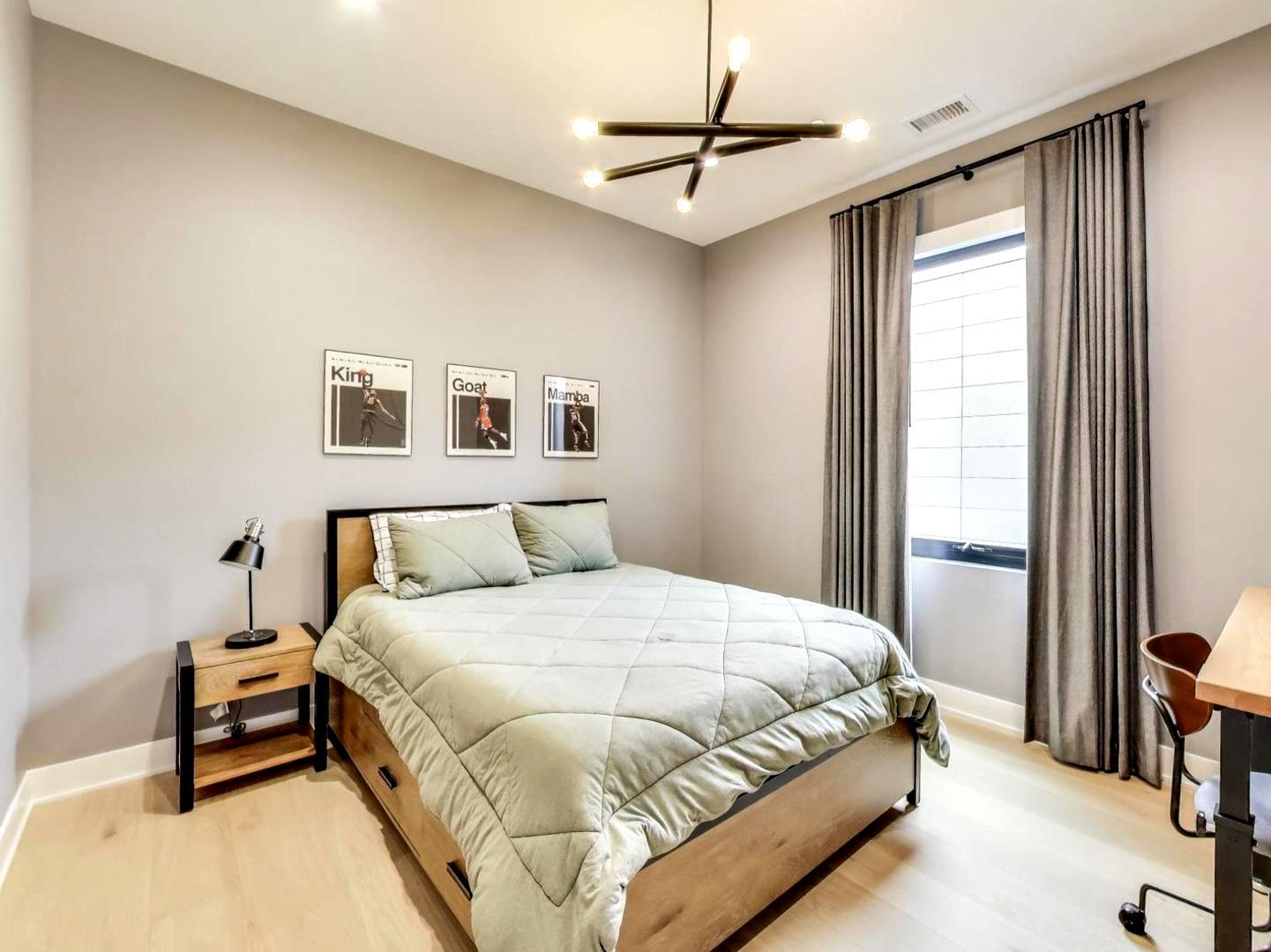 6 North Carpenter Street, Unit 5B Chicago, IL 60607 - Photo 25 of 40 a bedroom with a bed a chandelier and a window