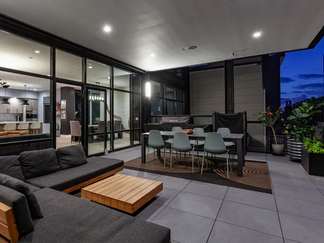 a living room with furniture a table and kitchen view