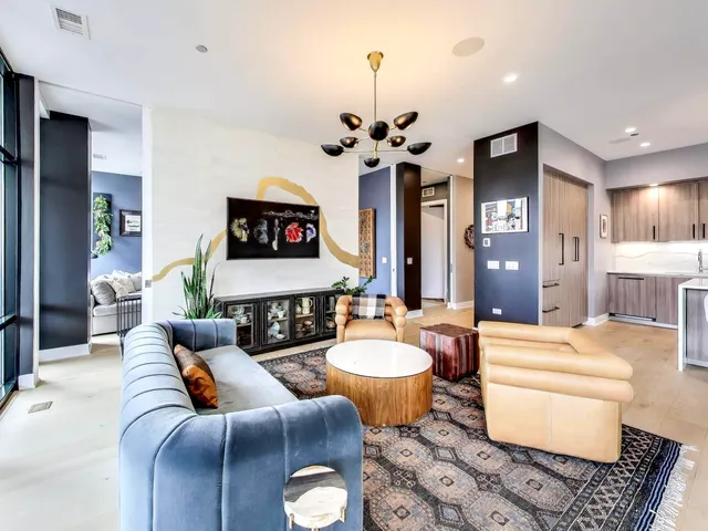 a living room with furniture a chandelier and a flat screen tv