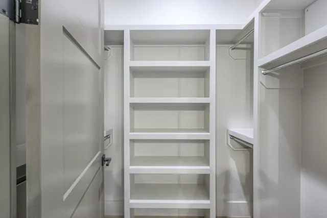 a view of walk in closet with empty racks