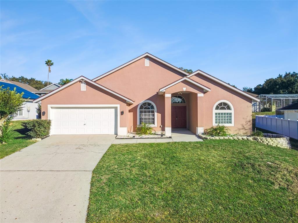 a view of a house with a yard and large trees