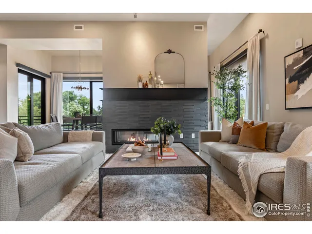 a living room with furniture a large window and a fireplace