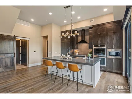 a kitchen with stainless steel appliances kitchen island granite countertop a sink cabinets and wooden floor