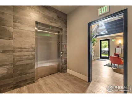 a view of a hallway with wooden floor and a bathroom