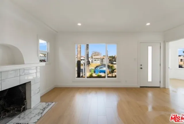 a view of a livingroom with wooden floor and a fireplace