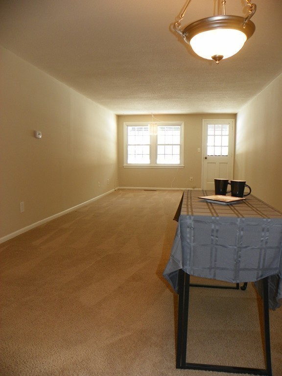 3 Elm Street, Unit 1 Acton, MA 01720 - Photo 4 of 12 a bedroom with a bed and a chandelier