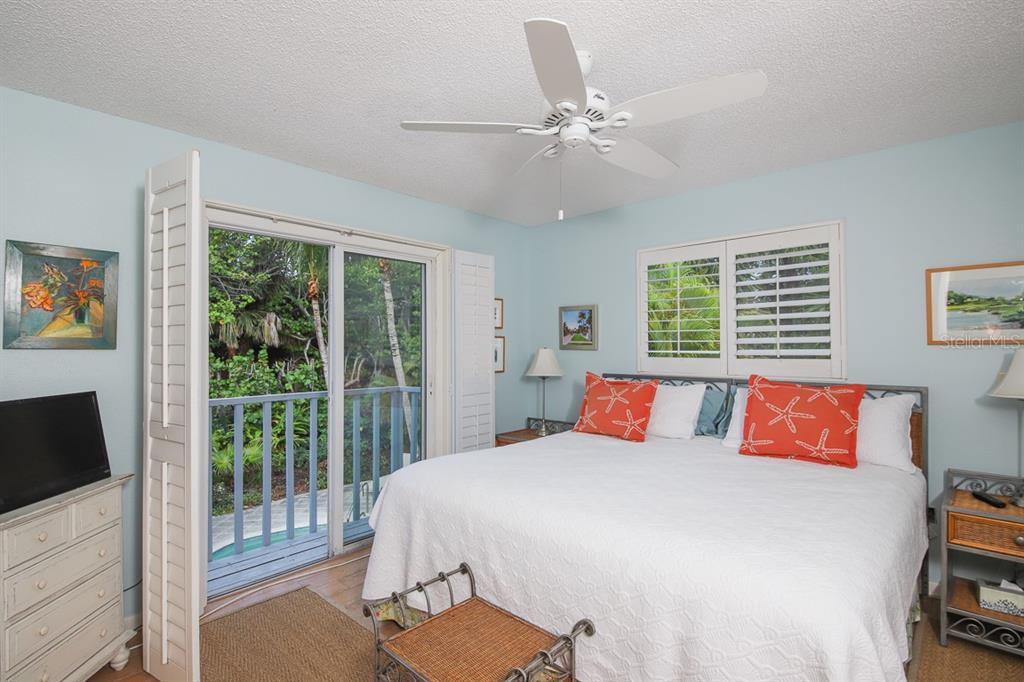 212 Pilot Street Boca Grande, FL 33921 - Photo 18 of 43 a bedroom with a large bed and a flat tv screen