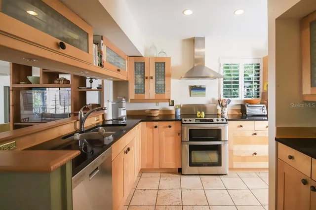 a kitchen with stainless steel appliances a stove sink and cabinets