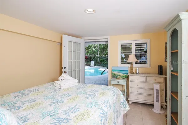a bedroom with a bed and a dresser next to a window